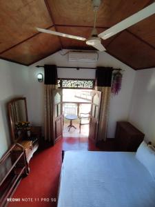 a bedroom with a bed and a ceiling fan at Sithula Villa in Bentota