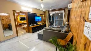 a living room with a couch and a television at Mount kirola stay in Bhowāli