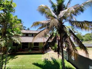 a palm tree in front of a house at Sithula Villa in Bentota