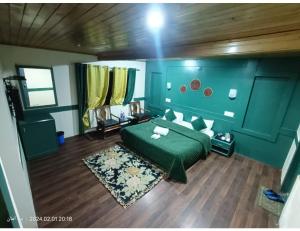 a bedroom with a green bed and a wooden floor at Hotel Alpine Ridge, Gulmarg in Gulmarg