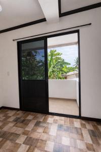 an empty room with a black door and windows at Tribo Zamani in General Luna
