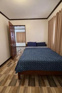 a bedroom with a bed with a blue comforter at Tribo Zamani in General Luna