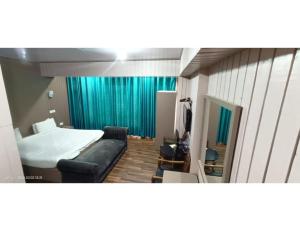 a bedroom with a bed and a couch in a room at Hotel Alpine Ridge, Gulmarg in Gulmarg +10 photos