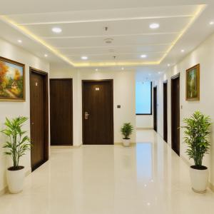 a hallway with two potted plants in a building at The W H I T E Amritsar in Amritsar +12 photos