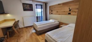 a hotel room with two beds and a desk and a deskablish at Penzion Tavcar in Ljubljana