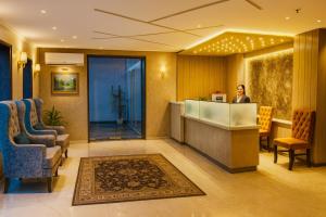 a woman standing at a reception desk in a hotel lobby at The W H I T E Amritsar in Amritsar