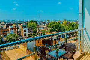 a table and chairs on a balcony with a view of a city at The W H I T E Amritsar in Amritsar