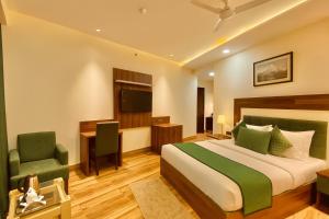 a bedroom with a bed and a desk and a television at The W H I T E Amritsar in Amritsar