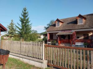 a wooden fence in front of a house at Mohos Vendégfogadó in Kelemér