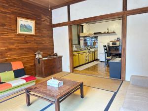 a living room with a couch and a table at Guesthouse Azumaya 2nd in Matsumoto