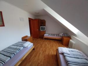 a attic room with two beds and a couch at Mohos Vendégfogadó in Kelemér