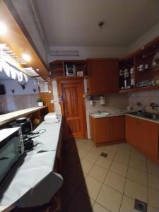 a kitchen with wooden cabinets and a white counter top at Mohos Vendégfogadó in Kelemér +11 photos