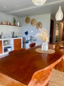 a dining room table with a vase of flowers on it at Oceanview Cottage Cempaga - entire 2 BR Bungalow 135 sqm in Temukus
