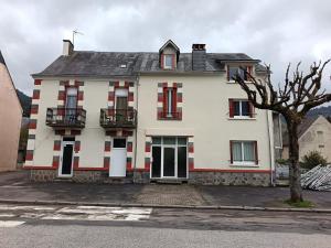 a large white house with red and white windows at Gite le Buron in La Bourboule