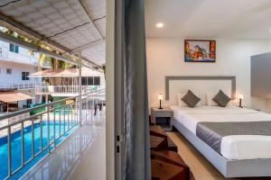 a bedroom with a bed and a swimming pool at Beach Walk Resort Walk In Morjim Beach Goa in Morjim