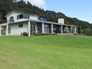a house on a hill with a large yard at Flaxmill Cove B&B in Whitianga