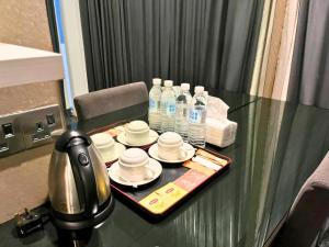 a table with plates and bottles of water on it at Seeds Hotel Premier One City Subang Previously eCity Hotel One City in Subang Jaya