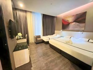 a hotel room with two beds and a tv at Seeds Hotel Premier One City Subang Previously eCity Hotel One City in Subang Jaya