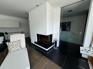 a living room with a white couch and a fireplace at Villa in Tyrol with pool in Stanz bei Landeck