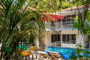 a house with a swimming pool next to a resort at Beach Walk Resort Walk In Morjim Beach Goa in Morjim +24 photos
