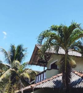 a building with palm trees in the foreground at Sithula Villa in Bentota