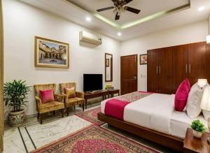 a bedroom with a bed and a desk and chairs at Monarch Residency Gurgaon in Gurgaon