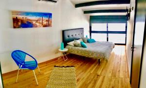 a bedroom with a bed and a blue chair at Private Hot Tub All Year Round - 25 min Lisbon in Setúbal