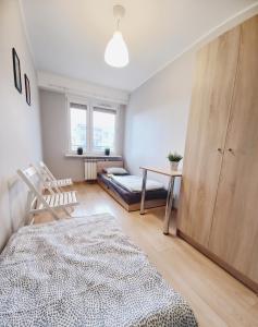 a bedroom with a bed and a desk and a table at Dobre Sny na Konopnej in Bydgoszcz