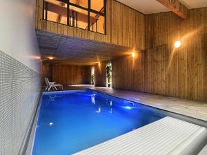 an indoor swimming pool in a house with a building at Malmedy Luxe Retreat & Spa in Xhoffraix