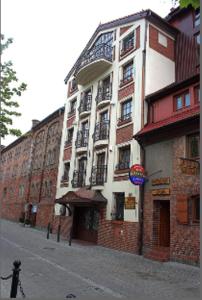 a large building on the side of a street at Pensjonat Oleńka in Ustka