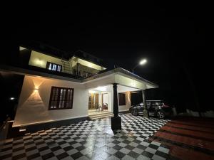 a house at night with a checkered floor at Richard's Homestay 7 BHK in Thiruvalla