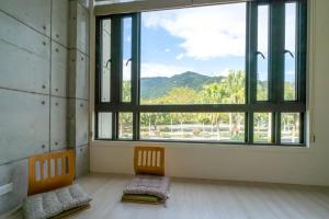 a room with two chairs and a large window at 伊旅旅宿民宿 in Guangfu