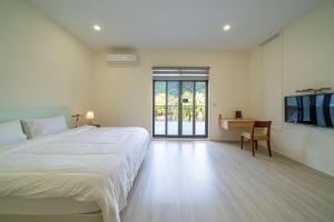 a bedroom with a bed and a desk and a tv at 伊旅旅宿民宿 in Guangfu +16 photos