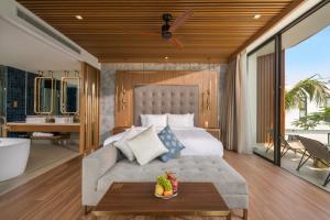 a bedroom with a bed and a tub and a table at Aqua Vista Hoi An Beachfront Villas in Hoi An
