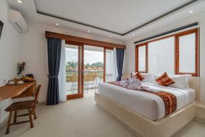 a bedroom with a bed and a desk and windows at Cahya Restu Ubud Villa in Ubud +43 photos