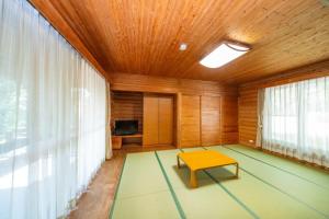 a living room with a table and a television at Kyukamura Taishakukyo in Shōbara