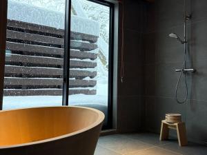 a bath tub in a bathroom with a window at KOMU Hakuba in Hakuba +18 photos