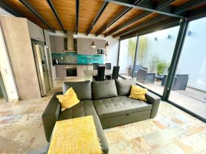 a living room with a couch and a kitchen at Private Hot Tub All Year Round - 25 min Lisbon in Setúbal