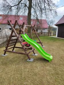 a playground with a green slide in a yard at Chalupa U lípy in Horní Bělá