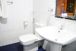 a white bathroom with a toilet and a sink at Villa - Nil Vimana - Ella in Ella +37 photos