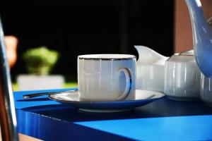 a cup on a plate on a blue table at Villa - Nil Vimana - Ella in Ella