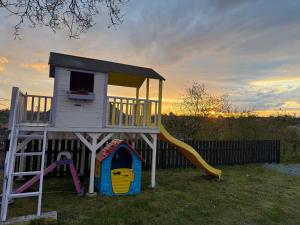 a playground with a play house and a slide at Cavria in Şurdeşti