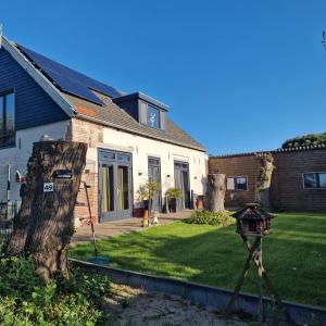 a house with a yard with a bird feeder at DuinDroom bovenappartement, Beverwijk in Beverwijk