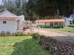 a white building with flowers in the yard at Milestone Heritage Inn in Jāmb