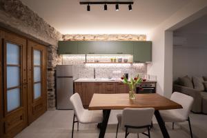a kitchen and dining room with a wooden table and chairs at The Alley in Litochoro