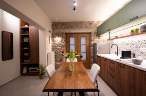 a kitchen with a wooden table with flowers on it at The Alley in Litochoro +6 photos