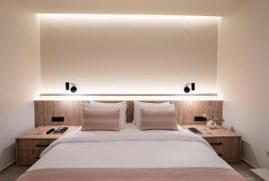 a bedroom with a large white bed with two night stands at The Alley in Litochoro