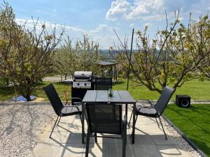 a patio with a table and chairs and a grill at Horizon Hill in Cserszegtomaj