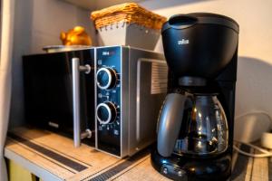 a coffee maker on a counter next to a microwave at Pension An der Bleiche in Wustrau