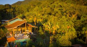 a house in the middle of a hill with trees at Haleiwa chalés e suítes - A Guest House do Prumirim in Ubatuba